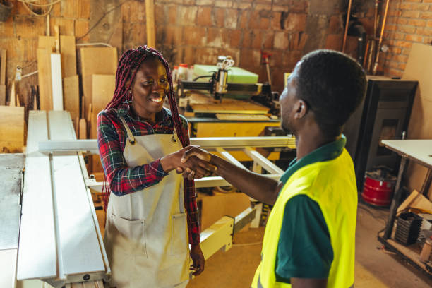 Shot of two young contractors standing in the warehouse together and shaking hands